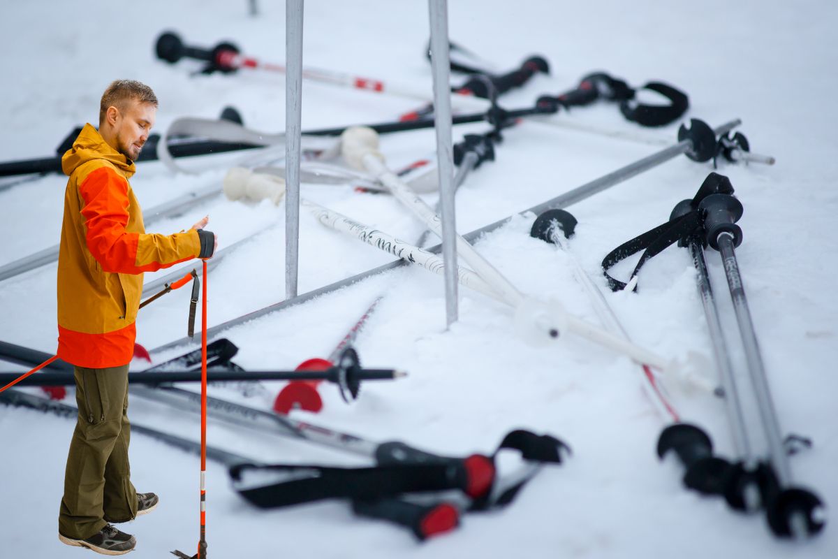 Un sportif fait le choix de son bâton de ski.