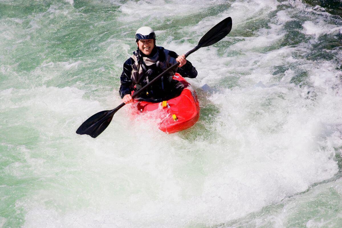 Un sportif amoureux des sensations fortes pratique le Kayak en eaux vives tout seul.