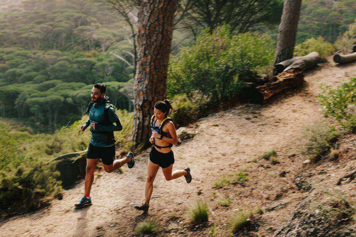 Un jeune couple effectue le trail running comme sport préféré.