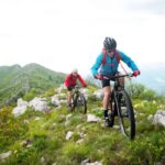 Deux athlètes font du vélo de montagne sur les sentiers les plus techniques et les plus époustouflants.